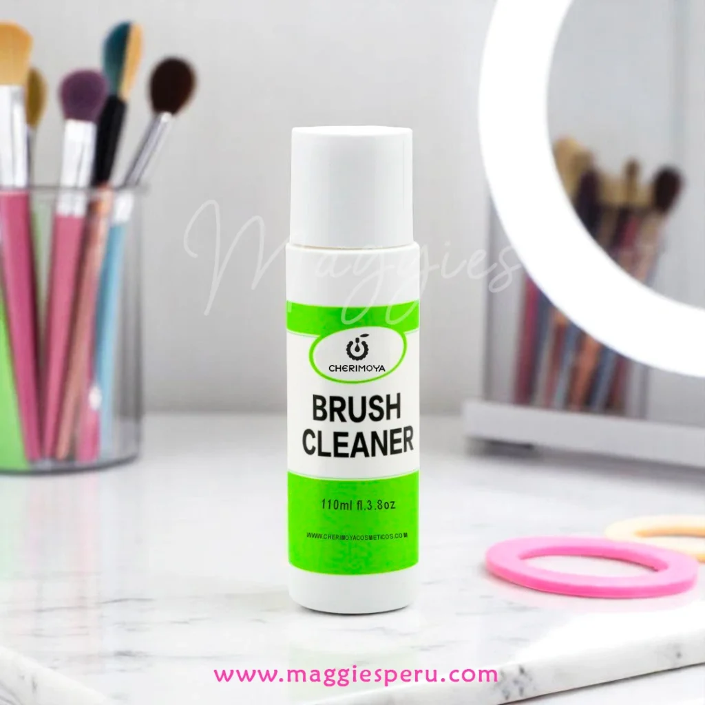 Limpiador de pinceles Cherimoya 110 ml sobre mesa de mármol, brochas de maquillaje y aro de luz al fondo