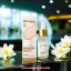 Serum de Arroz Bioaqua 15ml junto a su caja y flores blancas en un fondo difuminado